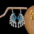 Detail of silver peacock earrings with blue enamel wings and hanging bell charms - Multicolor Enamel Peacock with Bell