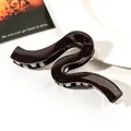 Close-up of a large wavy brown hair claw clip with a high-gloss finish on a white surface - 13cm Geometric Wave - Shiny Dark Coffee