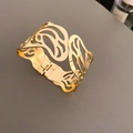 Detail van gouden opengewerkte armband met vlindervleugelpatroon en scharniersluiting - Vlinder Holle Scharnierende Stijl / Goud