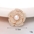Detail showing a 3.5cm rhinestone camellia flower brooch with a central pearl inlay - Pearl Flower (Gold Base White)