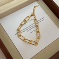 Dettaglio della catena a maglie dorate con marchio in acciaio inossidabile 316L sulla targhetta - Bracciale Oro