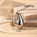 Silver teardrop necklace with hammered metal texture on a beige stone base - NK-187 Silver Medium Teardrop Necklace