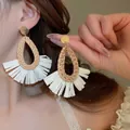 Detail of bohemian raffia tassel earrings with woven rattan teardrop frame and gold studs - 7# Steel Needle - Natural Color Teardrop Tassel