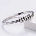 Macro shot of silver titanium steel bracelet featuring five sparkling rhinestone rings - Steel Color Bangle / Steel