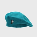 Macro detail of turquoise knit beret showing textured fabric and black P letter patch - Teal