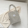 Minimalistische beige gewebte Tragetasche mit Karomuster und modischem Anhänger - Hellgrau