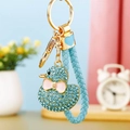 Detail of light blue rhinestone duck keychain with woven strap and golden metal ring - Braided Blue Rhinestone Duck