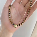 Detail of layered gold snake chain and tiger eye beaded necklace worn by a model - Brown Bead