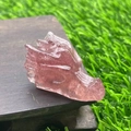 Carved dragon head statue made of translucent pink crystal on a wood base - Strawberry Quartz