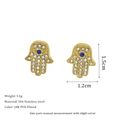 Macro view of Hamsa Hand stud earrings with 18K gold plating and cubic zirconia detail - Blue