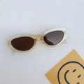 Translucent amber cat-eye sunglasses with dark brown lenses on a textured surface - Champagne
