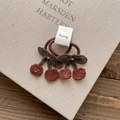 Detailed close-up of cute knitted cherry hair ties with smiling face embroidery - Knitted Cherry Hair Tie-Red