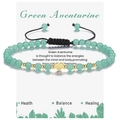 Macro shot of 4mm green aventurine beaded bracelet with gold heart charm on jewelry card - Green Aventurine