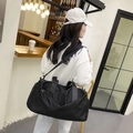 Grote zwarte nylon reistas met nat-droog scheiding getoond in een café-omgeving - Zwart