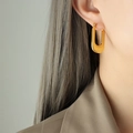 Eleganti orecchini a cerchio rettangolari a U placcati in oro 18k indossati da modella - F671 Forma U Righe / Oro