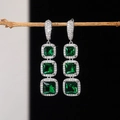 Detalle de pendientes de circonita verde esmeralda con engaste de halo brillante - Verde