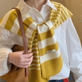 Detail of yellow and white striped knitted shawl draped over a white shirt - Yellow