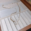 Close-up of a zircon pearl pendant necklace with sparkling rhinestones on a beige velvet box - Zircon Pearl Pendant Fragmented Silver Necklace