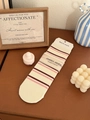 Detailaufnahme weißer Baumwollsocken mit roten Streifen auf einer warmen Holzoberfläche - Gestreift Weiß Rosa