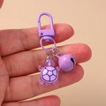 Close-up of purple resin turtle keychain with metal bell and lobster clasp for bags - Purple