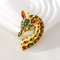 Broche girafe colorée avec strass et émail sur un support de présentation blanc - Coloré