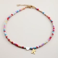 Detail of colorful beaded necklace with a white heart shell and golden letter K pendant - Letter K