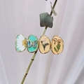 Detalle de pinzas ovaladas para el pelo en resina artesanal con flores secas y mariposas - Serie Azul Claro