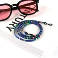 Detail of colorful woven bohemian glasses strap with metal sliders and rubber connectors - US 5