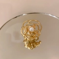 Detalle macro de pinza de pelo de camelia dorada con centro de perla elegante en espejo - Dorado Pequeño