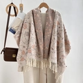 Detail eines beigen und rosa geblümten Strickschals mit Quasten auf Holzfalle - Beige