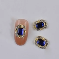 Golden nail charm with large rectangular blue gemstone and surrounding clear rhinestones - Gold Base Blue Rectangle Gemstone