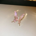 Dettaglio macro dell'orecchino a clip a farfalla in smalto rosa con lega dorata su pelle - Clip per Orecchio a Farfalla in Smalto Rosa