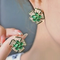 Elegant emerald green flower stud earrings with brilliant zircon stones worn by model - Green