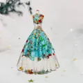 Macro detail of crystal gown figurine featuring blue stones and gold star sequins - Turquoise