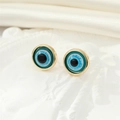 Macro view of vintage round evil eye stud earrings with blue resin and golden frames - Gold Dark Green Glitter Eye