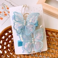 Dettaglio di fermagli per capelli a farfalla in tulle blu con paillettes e perline - Blu