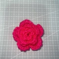 Close-up of a 7cm bright pink hand-knitted three-layer crochet flower for accessories - 7cm / Iceland Yarn Rose Red