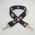 Detail of adjustable wide bag strap featuring white daisy patterns on black nylon webbing - No. 11 Black Orange Floral