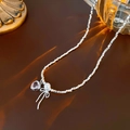 Silver necklace featuring a pink heart gem, white pearl, and a silver bow pendant - Necklace - Silver