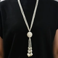 Elegante collana lunga a due fili di perle con nappa e ciondolo a sfera su maglione nero - Stile Sfera