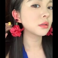 Gros plan de grandes boucles d'oreilles fleur rouge portées par un mannequin de style - Rouge (9# Tige en Argent)