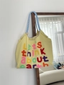 Nahaufnahme der Erdstickerei und des blau karierten Trageriemens am Canvas-Shopper - Gelb
