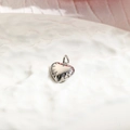 Detailed view of a small polished silver heart pendant with fine radial textures - Heart / Silver