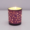 Purple glass candle jar with gold star pattern and warm glowing flame - Purple Star