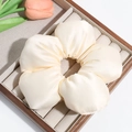 Detail shot of a cream satin flower hair tie on a luxury wooden jewelry display tray - Beige (Approx. 14.5cm)