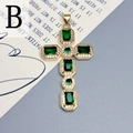 Dettaglio di un ciondolo a croce dorata con zirconi verde smeraldo e pavé di pietre - Verde-B