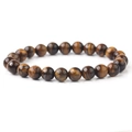 Macro shot of polished round tiger eye stone beads with natural chatoyancy textures on a bracelet - Yellow Tiger Eye