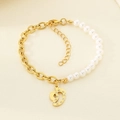 Detail of gold chain and pearl bracelet featuring a crystal footprint pendant charm - Rhinestone Footprint Pendant (KB203696-Z)
