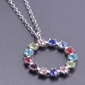 Macro shot of circular stainless steel pendant with multi-colored crystals on a silver chain - Silver Necklace