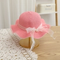 Pink straw sun hat with wavy edges and organza bow detail on a golden display stand - Watermelon Red Hat